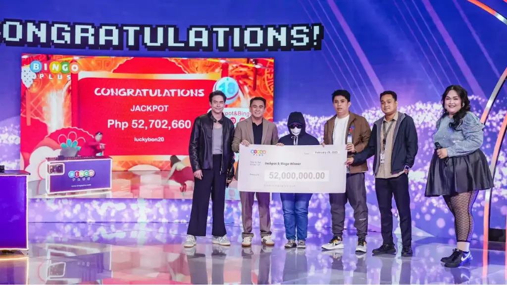Lucky BingoPlus player receiving a mock check of her winning jackpot prize of ₱52,000,000.